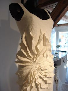 a dress made out of white fabric on a mannequin