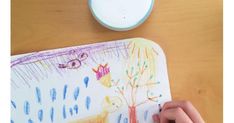 a child's drawing on a mouse pad with an alarm clock in the background