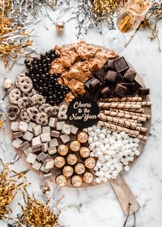 a platter filled with chocolate, marshmallows and pretzels for new year's eve