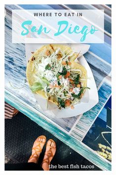 a taco sitting on top of a table next to a person's feet