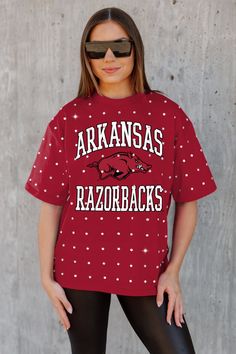 a woman wearing a red shirt with white polka dots and the words arkansas razorbacks on it