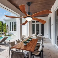 a ceiling fan that is on top of a table in front of a swimming pool