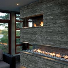 a living room with a fire place next to a couch and chair in front of a large window