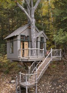 a tree house in the woods with stairs leading up to it's second floor