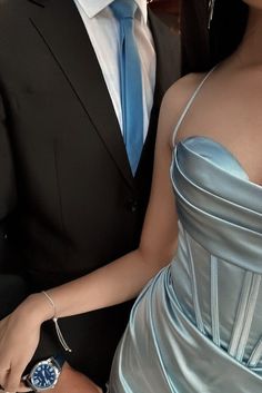 a woman in a blue dress and a man in a black suit