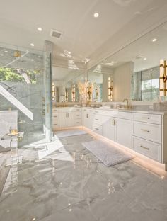 a large bathroom with marble flooring and white walls, along with two sinks on either side of the bathtub