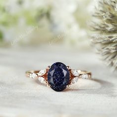 a blue and white diamond ring sitting on top of a table