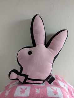 a pink bunny pillow sitting on top of a bed