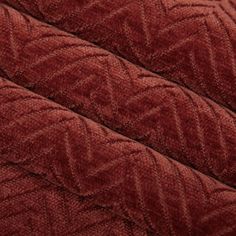 closeup of the texture of an upholstered red velvet fabric with wavy lines