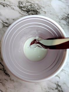 a white bowl filled with yogurt sitting on top of a marble counter