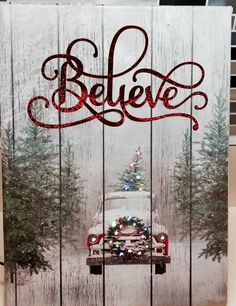 a wooden sign with the words believe painted on it and a christmas tree in the back