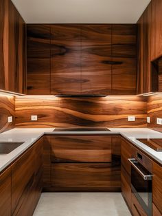 a kitchen with wooden cabinets and white counter tops on both sides of the sink area