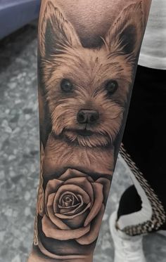 a small dog with a rose tattoo on the arm is shown in black and white