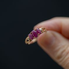 Get ready to make a statement with this stunning handmade, vintage trilogy ring crafted from high-quality 10k yellow gold. This ring boasts three magnificent pinkish red rubies and two dazzling accent diamonds that will take your breath away. The center stone measures 5.5mm x 3mm, while the two stones on either side measure 4.5mm x 3mm, all held securely in place by elegant prongs. The split shank design at the top of the ring leads down to a straight shank, ensuring a comfortable and snug fit o Ruby Trilogy Ring, Three Stone Ring Design, Red Three-stone Diamond Promise Ring, Red Three Stone Diamond Ring For Promise, Red Three Stone Diamond Promise Ring, Classic Three Stone Ruby Promise Ring, Three Stone Ruby Ring In 14k Yellow Gold, Heirloom Three Stone Red Rings, Classic Three-stone Ruby Ring