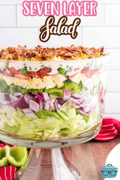 a layered salad in a glass dish with the words seven layer salad above it on top