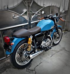 a blue motorcycle parked next to a metal structure