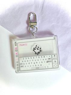 a keychain with a white keyboard attached to it's side and an animal on the front