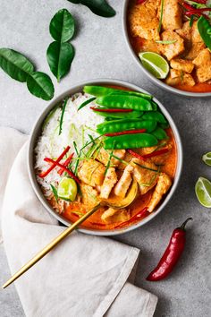 two bowls filled with chicken, rice and green peppers on top of a white napkin