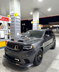 a grey jeep parked in front of a gas station