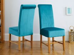 two blue chairs sitting next to each other on a hard wood floor