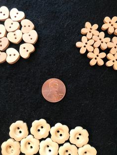 some buttons and a penny on a black surface