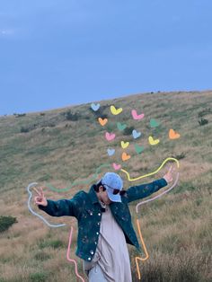 a man standing on top of a grass covered field holding a kite in the air