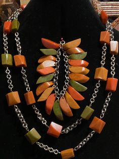 For Sale is a rare 1930's Deco Bakelite Suite. The necklace has 22 Bakelite Faceted Multi Color Cubes on a Brass Chain. It measures 29" can be wrapped as double chain necklace. The bracelet has 20 multi color Bakelite slices that hang individually like a charm bracelet. The earrings are clip-on. They measure 1.5 inches. This suite is in excellent condition. The colors are orange, green and mustard. Luxury Vintage Bakelite Jewelry, Multicolor Chain Jewelry, Unique Multicolor Chain Jewelry, Vintage Double Strand Chain Jewelry, Vintage Multicolor Jewelry With Unique Variations, Multicolor Vintage Jewelry With Unique Variations, Multicolor Costume Jewelry Necklace For Collectors, Vintage Multicolor Double Strand Jewelry, Vintage Multi-strand Jewelry With Natural Stones