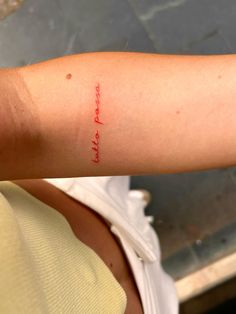 a woman's arm with red ink that says, i love you and she is wearing