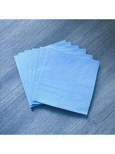 four blue napkins sitting on top of a wooden table