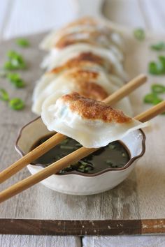 some food is sitting in a bowl with chopsticks sticking out of the top