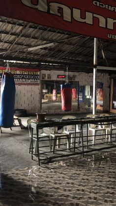 there is a boxing ring in the middle of an indoor gym with punching gloves on it