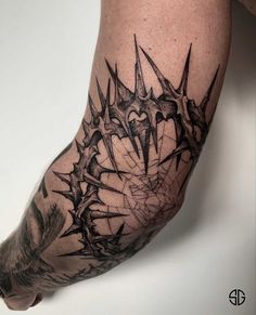 a man's arm with black ink and spikes on the leg, which are all over his body