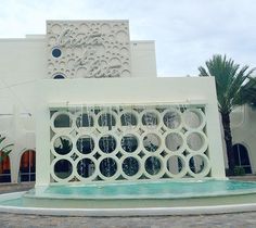 a white building with a fountain in front of it