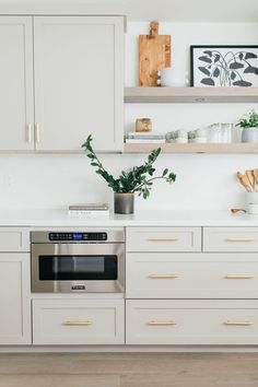 a kitchen with white cabinets and gold pulls on the drawers is pictured in this image