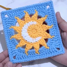 a crocheted square with the sun and moon on it in yellow and blue