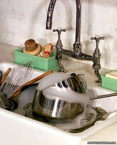 a sink filled with dishes and utensils in front of a faucet