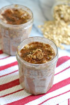 two jars filled with food sitting on top of a red and white table cloth next to gold flakes