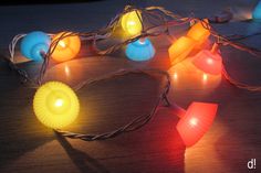 several colorful lights on a table with string and cords around them, all lit up