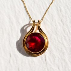 Gold Ruby Pendant set with a Created Ruby in a flawless diamond cut & bright red color, at 18mm (20 Carats).  Gold Vermeil: 18k Gold over Solid 925 Sterling Silver ☞ made to last. Matching Ring & Earrings - please ask me Details : ♥ Each item comes in a cute GIFT BOX ✓ ♥ GUARANTEE on all materials ✓ ♥ 18k Gold over Solid 925 Sterling Silver ✓ ♥ Each stone set professionally - WellMade Craftmanship ♕ ♥ More Beautiful jewellery on www.etsy.com/shop/AdinaStone ☜ ✉ Shipping by Royal Mail ✉ Tracked Shipping Option - worldwide tracking - choose at checkout: U.K. 1 Day delivery ! USA & Worldwide ✈ 5-7 Days Standard Shipping speed: U.K. ✈ 2-3 days USA ✈ 5-10 days Europe (all countries) ✈ 5-7 Days Rest of the world ✈ 8-18 Days *as stated by Royal Mail Fine Quality Jewelry ♥ Handmade in Europe ♥ Art Ruby Pendant Set, Statement Necklace Gold, Flawless Diamond, Ruby Pendant, Gold Statement Necklace, Red Necklace, Necklace Statement, Round Pendant, Boutique Jewelry