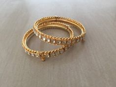 *This is Gold Finish Kundan Bangles pair.Its Perfect for Wedding Occasion as well as Unique and Ethnic Traditional Bangle to gift and Also Bridal wear to match with Wedding Outfits. *Its made from Silver n Copper mix material and 100% Handmade. *Its available in Various Sizes like 2,2.2,2.4,2.6 Etc Its white kundan combination like shown in picture. *Its open able Screwed Bangles Pair. *All Kundan stones set with silver foils handsetting method and long last guarantee of its workmanship.It is Wh Bollywood Style Bracelets With Intricate Design For Receptions, Bollywood Style Bracelets For Reception With Intricate Design, Stone Work Bracelets For Diwali Reception, Stone Work Bracelets For Reception And Diwali, Bollywood Style Intricate Bracelets For Reception, Temple Jewelry Bangle With Stone Work For Reception, Traditional Meenakari Bracelets For Reception, Festive Bangle With Intricate Design For Reception, Traditional Heavy Bangle For Reception