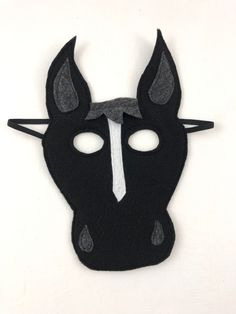 Black felt horse mask with a white stripe down the center of its face. On a white background. Handmade Black Costume Accessories For Costume Party, Black Novelty Costume For Costume Party, Black Novelty Costumes For Costume Party, Handmade Black Costume Accessories, Fun Black Costume Accessories For Cosplay, Fun Black Costume Accessories For Costume Party, Black Costume Accessories For Carnival Gift, Black Novelty Costume Accessories For Gift, Black Carnival Costume Accessories Gift