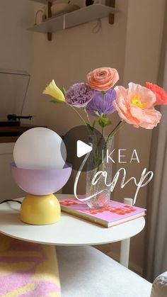 a vase with flowers sitting on top of a table next to a book and an egg