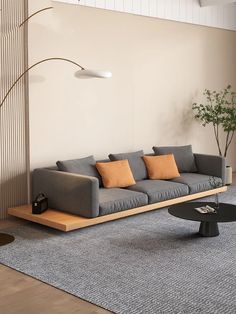 a living room with a couch, coffee table and lamp on the wall next to it