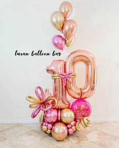 the balloon number 10 is surrounded by pink and gold balloons