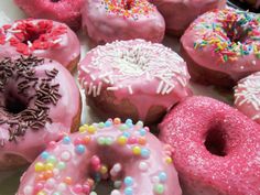 there are many pink donuts with sprinkles on them