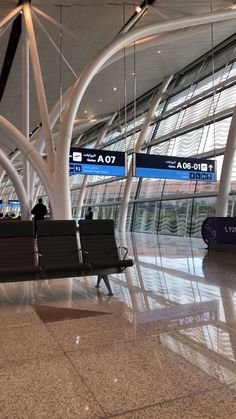 an airport terminal with several benches and signs