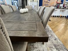 a wooden table surrounded by chairs in a store