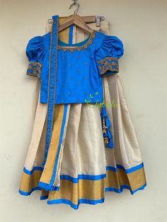 This Kerala traditional dhavani set includes 4 pieces- skirt, dhavani, crop top and a waist belt.  Fabric and Work: Top: Cotton silk Lined: Cotton Handwork: Bead worked neck line and small buttas scattered in front of top. A puff sleeve with hand worked boarder makes it beautiful. Opening: Hook closure at back Wash: Mild hand wash Skirt: Gold tissue kasavu cotton fabric and also lined with a cotton fabric to give comfort for your little one.  Color: Color of top can be customized according to your requirements. Size: The picture shows 6-8 year age group. Available 0-12 years. This is custom made as per your kids size. Post your order I will send you a measurements reference sheet using which you can provide details required to make your kids outfit. I will only start making this after you Blue Tilla Sets For Diwali, Traditional Blue Skirt Set For Festivals, Blue Skirt Set For Festive Navratri, Blue Skirt Set For Festivals, Traditional Blue Skirt For Festivals, Traditional Blue Festive Skirt Set, Blue Fitted Traditional Skirt Set, Traditional Blue Skirt, Dhavani Set