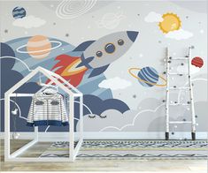 a space themed wallpaper in a child's room with a rocket ship and planets