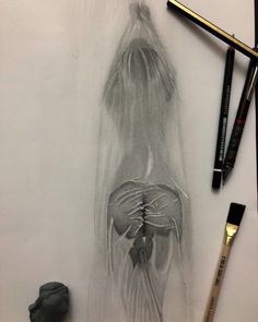 a pencil drawing of a woman's back with her hands on her hips and two other items nearby